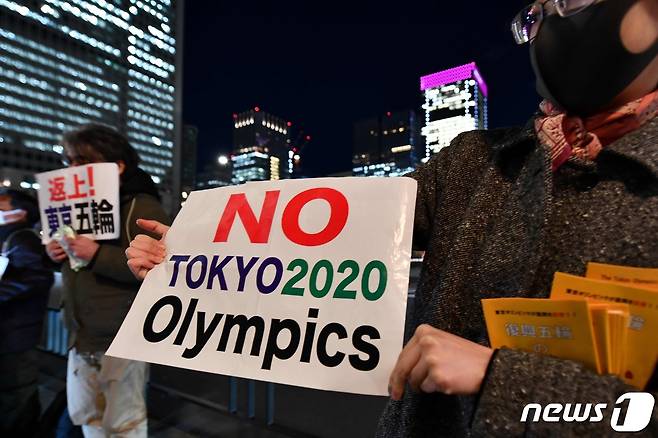 도쿄 올림픽 개최를 반대하는 사람들이 지난달 24일 도쿄 철도역 앞에서 시위를 하고 있다. © AFP=뉴스1