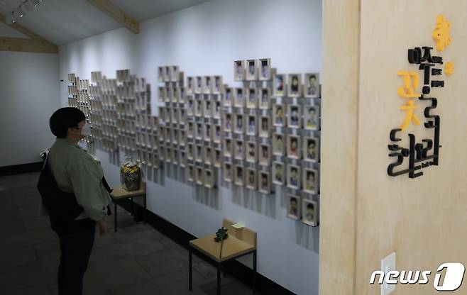 세월호 참사 7주기를 하루 앞둔 15일 서울 광화문광장 세월호 기억공간을 찾은 참사 당시 생존자가 희생자들의 사진을 둘러보고 있다. 2021.4.15/뉴스1 © News1 구윤성 기자