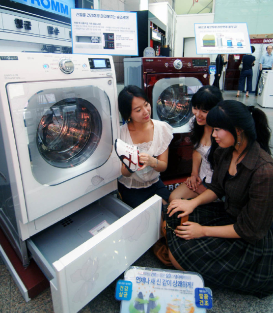 LG전자가 2008년 출시한 드럼세탁기에 탑재된 서랍형 신발관리기를 고객들이 체험하는 모습./사진제공=LG전자