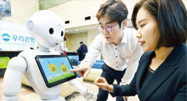 우리은행은 창구 안내와 금융상품 추천 등을 할 수 있는 감정인식 로봇 ‘페퍼’를 주요 지점에 설치하고 운영에 들어갔다. 
 허문찬 한국경제신문 기자 sweat@hankyung.com