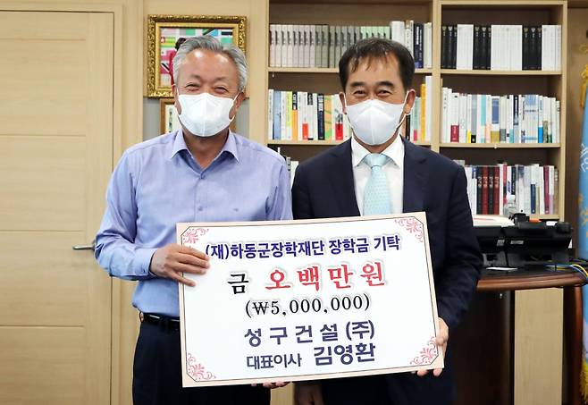 성구건설 김영환 대표(오른쪽)가 윤상기 하동군수에게 장학기금을 기탁하고 있다./사진제공=하동군