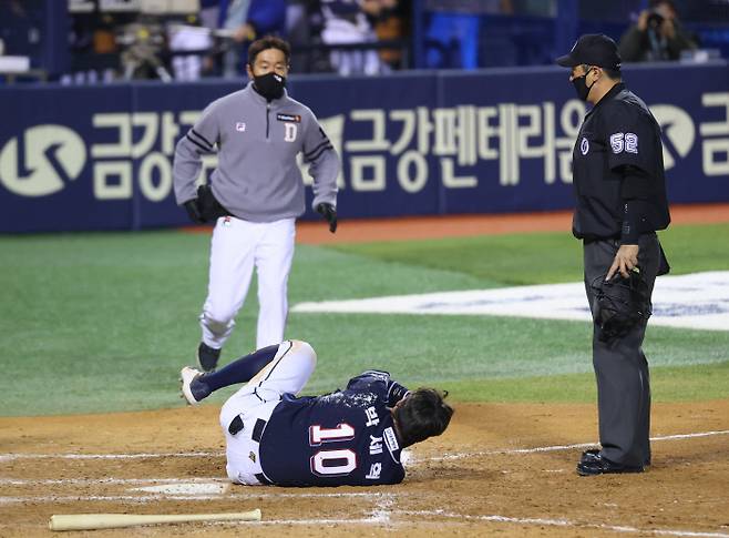 박세혁이 16일 잠실 LG전에서 투구에 얼굴을 맞은 뒤 쓰러져 고통스러워 하고 있다. | 연합뉴스
