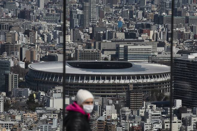 2020도쿄올림픽 주 경기장인 뉴 내셔널 스타디움 인근을 마스크를 낀 시민이 지나가고 있다. AP연합뉴스