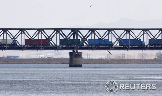 북한 신의주와 중국 단둥을 연결하는 '우호교' 위를 물자를 실은 트럭들이 줄지어 이동하고 있다. © 로이터=News1