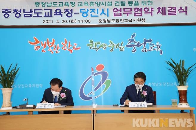김지철 충남교육감(왼쪽)과 김홍장 당진시장이 업무협약서에 서명하고 있다.