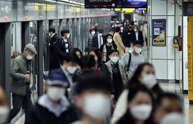 Masked commuters photographed at a Seoul subway station. (Yonhap)