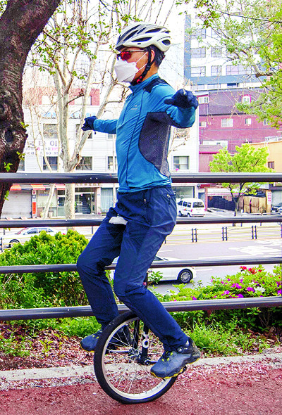 헬멧 등 안전장구를 갖춘 남호철 기자가 자전거도로에서 외발자전거 주행 연습을 하고 있다.