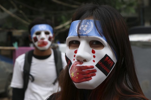 양곤의 쿠데타 규탄 시위대가 국제사회의 관심을 촉구하는 의미로 유엔 상징이 그려진 마스크를 쓰고 시위를 하고 있는 모습. 양곤=AP 뉴시스