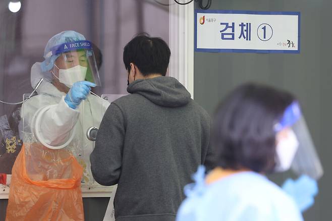 지난 17일 오전 서울역 광장에 마련된 임시선별진료소에서 의료진이 검체 채취를 하고 있다. 연합뉴스