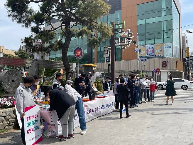 충북피플퍼스트센터가 22일 청주 성안길 입구에서 그림 투표 용지 도입을 위한 서명 운동을 하고 있다.