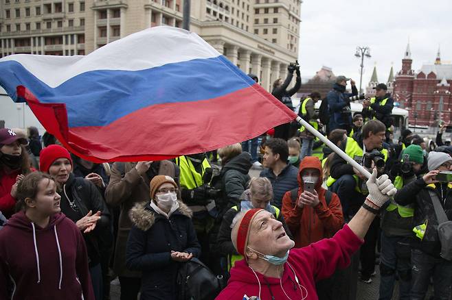 21일 러시아 수도 모스크바의 붉은 광장 인근에서 열린 알렉세이 나발니 석방 촉구 집회에서 한 참가자가 러시아 국기를 흔들고 있다. AP=연합뉴스