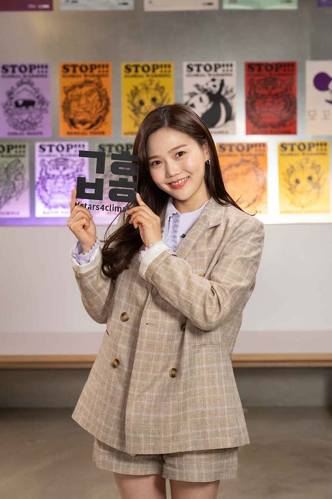 Hyojung from girl band Oh My Girl holds a sign showing the Hangeul abbreviation for "climate change." (Climate Media Hub)