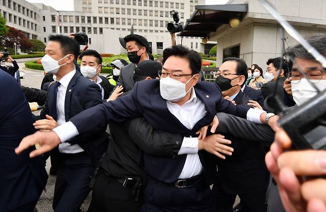 국민의힘 주호영 당 대표 권한대행(가운데 오른쪽), 김성원 원내수석부대표(가운데), 배준영 대변인(오른쪽)과 보수단체 회원 등이 23일 서울 서초구 대법원 앞에서 김명수 대법원장의 차량행렬에 다가가며 항의하다 경찰들에게 저지당하고 있다. ⓒ국회사진기자단