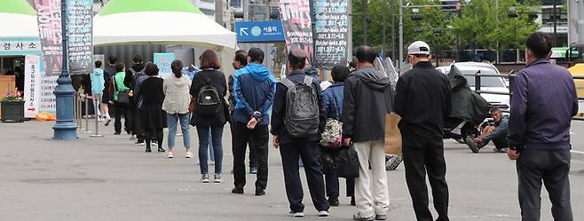 24일 중구 서울역 광장에 마련된 임시 선별검사소를 찾은 시민들이 신종 코로나 바이러스 감염증(코로나19) 검사를 받기 위해 줄지어 기다리고 있다. 뉴스1