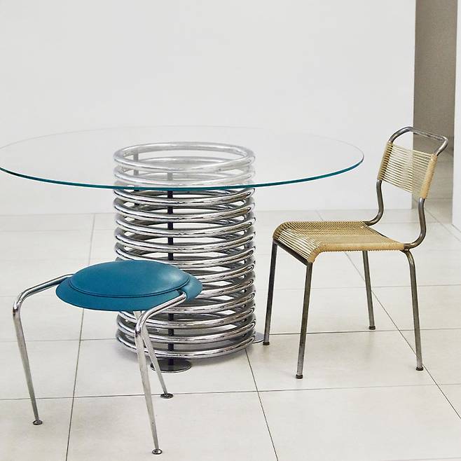 폴 메이언의 크롬 테이블과 함께 놓인 마시모 요사 기니의 디스코 스툴과 벨록스 체어.