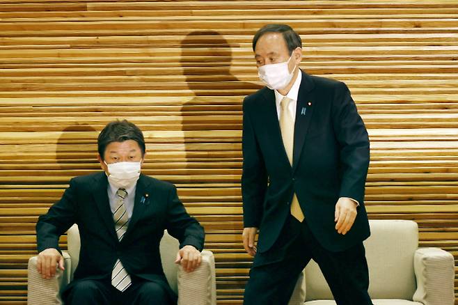 스가 요시히데 일본 총리(오른쪽)가 지난 23일 오전 일본 총리관저에서 각의에 임하고 있다. 연합뉴스