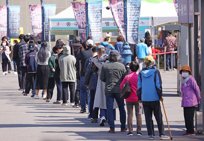 25일 서울역광장에 마련된 코로나19 임시선별검사소를 찾은 시민들이 검체 검사를 위해 줄지어 서 있다. 연합뉴스