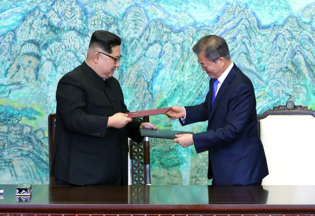 On April 27, 2018, President Moon Jae-in and North Korean leader Kim Jong-un exchange copies of the Panmunjom Declaration for Peace, Prosperity and Unification of the Korean Peninsula after signing the declaration at the Panmunjom Peace House. Yonhap News
