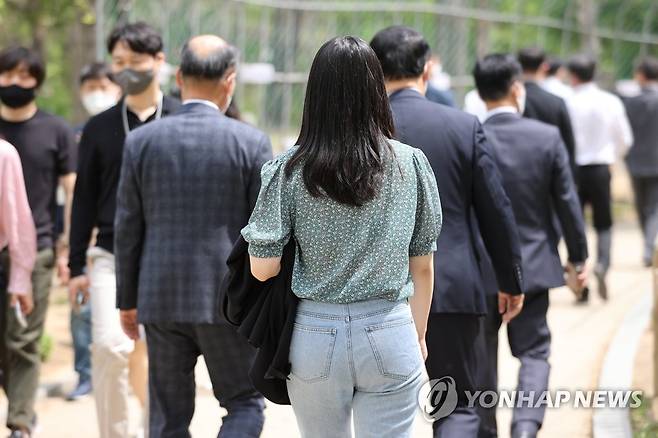 봄에 맞이한 여름 (서울=연합뉴스) 임화영 기자 = 낮 기온이 27도까지 올라가며 여름 날씨를 보인 지난 22일 정오를 넘긴 시간 서울 여의도공원에서 시민이 외투를 벗어 팔에 걸친 채 산책을 즐기고 있는 모습. [연합뉴스 자료사진]