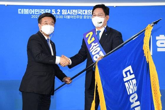 송영길 더불어민주당 신임 당대표가 2일 오후 서울 여의도 더불어민주당 중앙당사에서 열린 임시전국대의원대회에서 윤호중 비상대책위원장에게 당기를 건네받고 있다. 송 대표는 이날 온라인으로 진행된 민주당 전당대회에서 35.60%의 총득표율을 기록, 홍영표·우원식 후보를 제치고 승리했다. 뉴스1