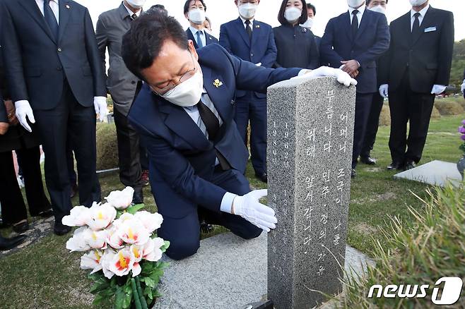 더불어민주당 당대표 경선에 나선 송영길 의원이 15일 오후 광주 북구 국립5·18민주묘지에서 참배를 마친 뒤 전영진 열사 묘비를 어루만지고 있다. 2021.4.15/뉴스1 © News1 황희규 기자