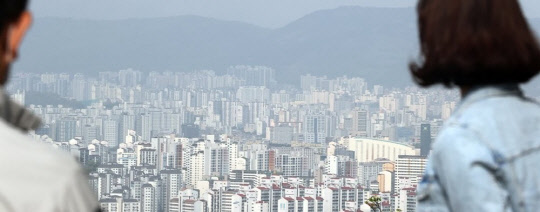 시민들이 서울 남산공원에서 도심 아파트 밀집 지역을 내려다보고 있다. <연합뉴스>