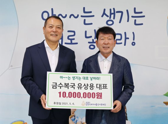 유상용 금수복국 대표(왼쪽)가 김영식세자녀출산지원재단 이사장에게 출산축하금 1000만원을 기부하면서 포즈를 취하고 있다. 김영식세자녀출산지원재단 제공