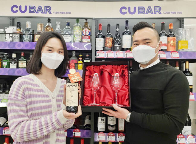 CU 점포에서 직원들이 자체 브랜드 `음!(mmm!)’과 함께 와인 용품을 소개하고 있다. [사진 제공=BGF리테일]
