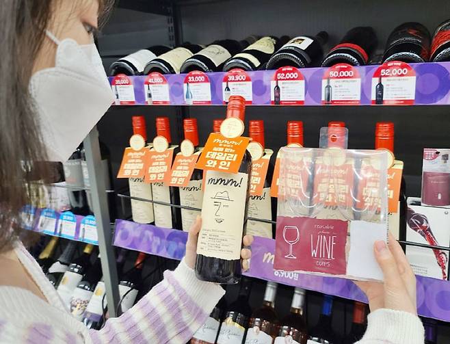 CU 점포에서 직원들이 자체 브랜드 `음!(mmm!)`과 함께 와인 용품을 소개하고 있다. [사진 제공=BGF리테일]