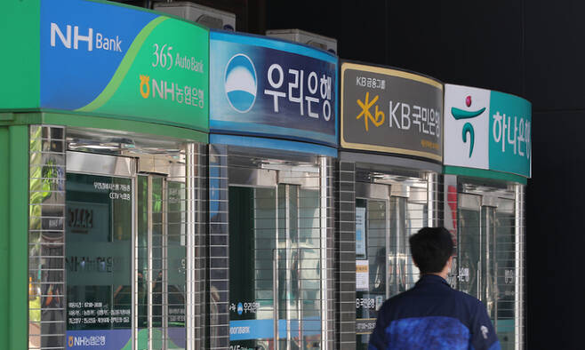 한 시민이 9일 서울 종로구의 시중은행 현금자동입출금기(ATM) 앞을 지나가고 있다. 최근 기준금리 조기 인상 가능성이 거론되는 가운데 시중은행의 금리가 빠르게 오르고 있다. 연합뉴스