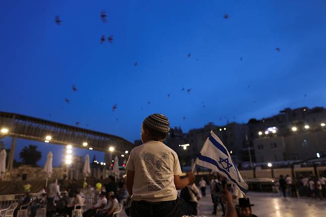 9일(현지시간) 국기를 손에 든 한 유대인 어린이가 예루살렘 올드시티 통곡의 벽을 방문하고 있다. 로이터
