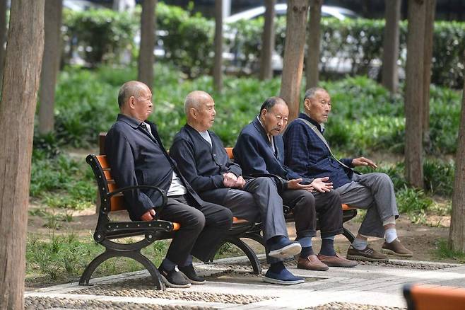 12일 중국 안후이성 푸양에 있는 공원에서 노인들이 벤치에 앉아 있다. 푸양/AFP 연합뉴스