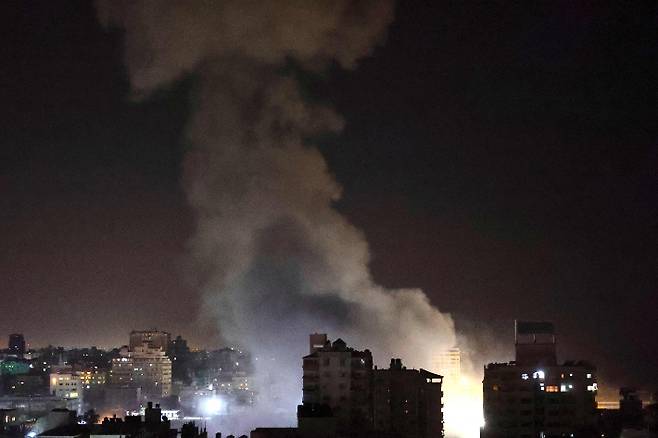 12일(현지시간) 이스라엘군 공습을 받은 팔레스타인 가자지구 한 건물에서 흰 연기가 피어오르고 있다. 연합뉴스