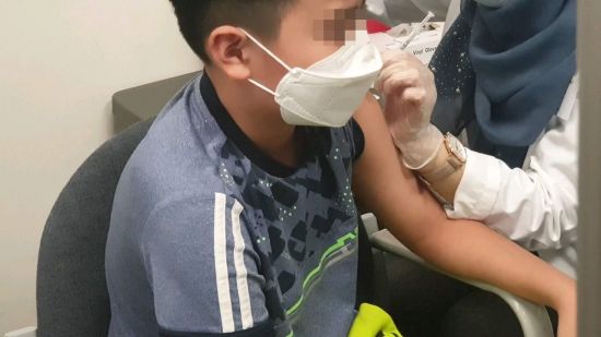 기자의 12세 아들이 화이자 코로나19 백신을 접종하고 있다.
