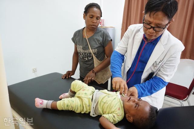 인도네시아 파푸아주 아시키의 피르만 아시키병원장이 고열에 시달리는 원주민 아기 에카를 진료하고 있다. 아시키=고찬유 특파원