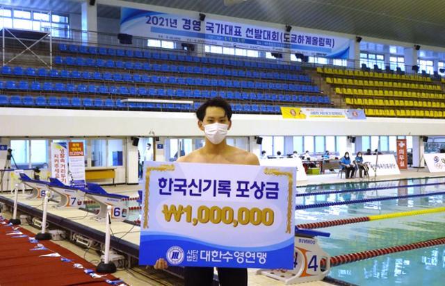 조성재가 13일 제주종합경기장 내 실내수영장에서 열린 2021 경영 국가대표 선발대회에서 남자 평영 100ｍ 부문에서 한국 신기록을 세우고 포상금을 받고 있다. 대한수영연맹 제공