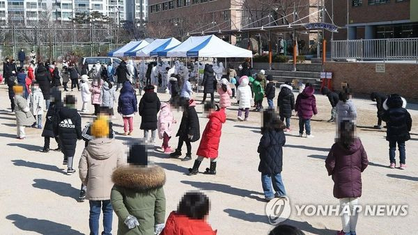 지난 2월 울산의 한 초등학교 운동장에 설치된 선별진료소에서 학생들이 코로나바이러스 감염증(코로나19) 진단 검사를 받기 위해 줄을 서고 있다.