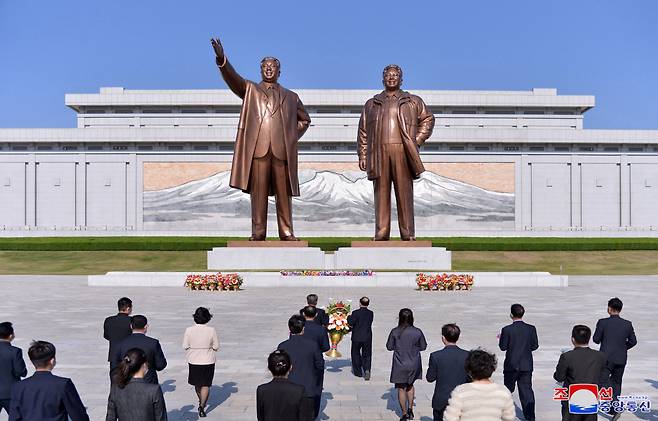 This photo, released by the Korean Central News Agency, shows North Korean people offering flowers in front of the statues of late North Korea founder Kim Il-sung and his late son Kim Jong-il in Pyongyang on the occasion of the 89th founding anniversary of the Korean People‘s Revolutionary Army on April 25. (Yonhap)