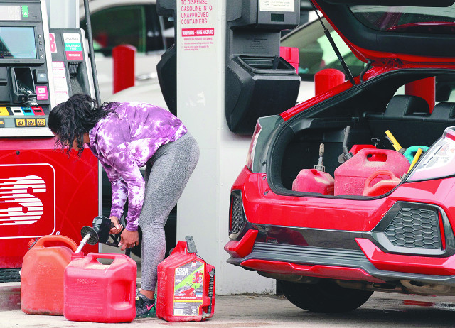 한 여성이 12일(현지시간) 미국 노스캐롤라이나주 벤슨의 한 고속도로 주유소에서 휘발유를 사재기하고 있다. 차 트렁크에도 휘발유통이 가득 차 있는 모습이다. AFP연합뉴스