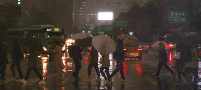 서울 광화문 사거리 건널목을 시민들이 우산을 쓰고 지나가고 있다. /연합뉴스