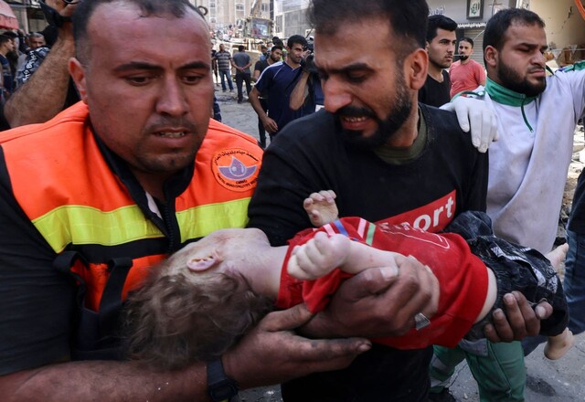 16일 팔레스타인 가자지구에서 구조대가 이스라엘 공습으로 파괴된 건물에서 발견한 아이의 주검을 옮기고 있다. 가자/AFP 연합뉴스