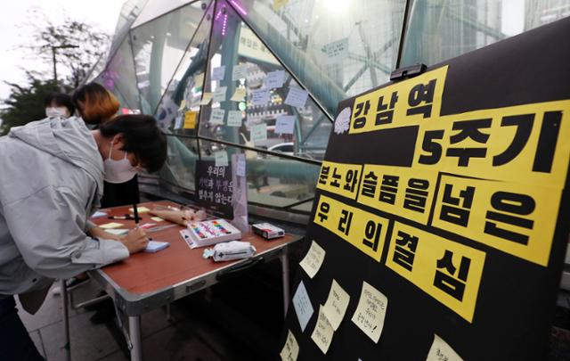강남역 살인사건 5주기인 17일 오후 서울 강남역 10번 출구 추모공간 앞에서 한 시민이 추모 메시지를 작성하고 있다. 뉴시스