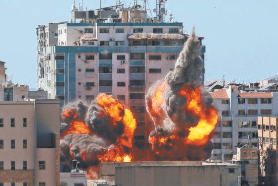 15일(현지시간) 이스라엘군의 공습을 받은 팔레스타인 가자지구 잘라 타워가 화염에 휩싸였다. 12층 높이의 건물에는 AP통신, 알자지라 방송 등 외국 언론사가 입주해 있는데 이스라엘군은 1시간 전에야 공습 사실을 알렸다. 결국 이 건물은 무너졌다. [AFP=연합뉴스]