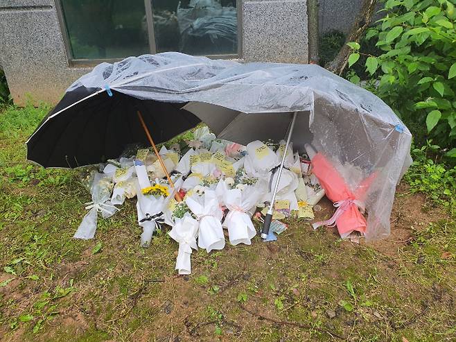 여중생 2명이 투신해 숨진 충북 청주의 한 아파트 화단에 이들을 애도하는 꽃다발이 놓여 있다. 독자 제공