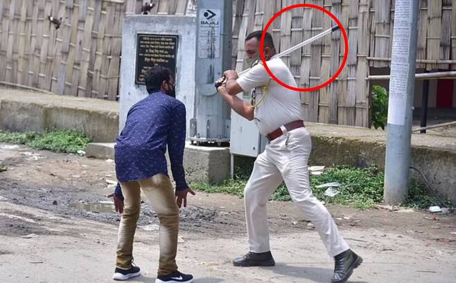 인도 동북부 아삼주의 한 경찰이 코로나19 확산을 막기 위한 통금 규정을 어긴 시민에게 몽둥이질 처벌을 하고 있다.