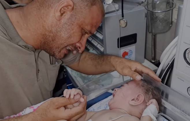 이스라엘군의 폭격으로 아내와 자녀 4명을 잃고, 유일하게 살아남은 막내 아이를 보며 눈물짓는 팔레스타인 남성