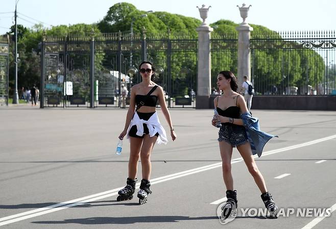 (모스크바 타스=연합뉴스) 낮 기온이 섭씨 영상 27도 이상의 이상 고온 현상을 보인 17일(현지시간) 모스크바 시내 고리키 공원에서 시원한 옷차림을 한 여성들이 롤러스케이트를 타고 있다.