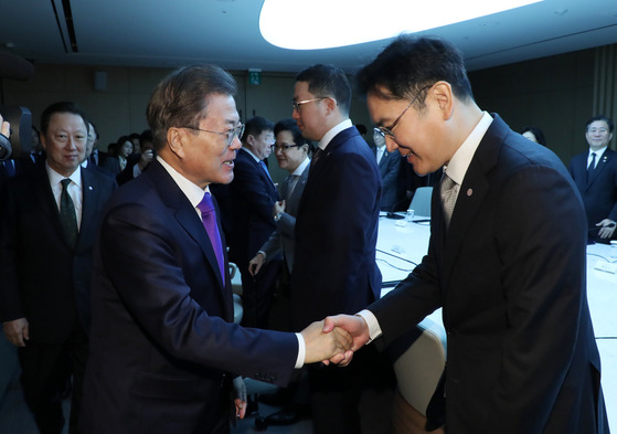 In this file photo, President Moon Jae-in, left, shakes hands with Samsung Electronics Vice Chairman Lee Jae-yong during a meeting with business leaders to discuss the country's response to the Covid-19 pandemic on Feb. 13, 2020. [Joint Press Corps]