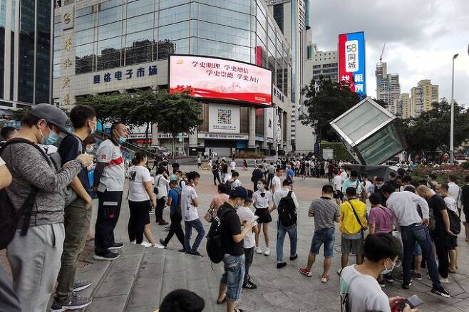 18일 오후 중국 선전시 푸톈구 소재 화창베이 전자상가에 있는 SEG 플라자 앞에 건물 흔들림으로 대피한 이들이 여기저기 모여있다. 선전=AFP연합