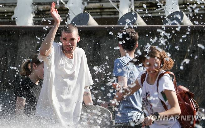 (모스크바 타스=연합뉴스) 봄철 이상 고온 현상이 계속있는 모스크바에서 18일(현지시간) 주민들이 크렘린궁 인근 공원 분수대를 찾아 물놀이를 즐기고 있다.